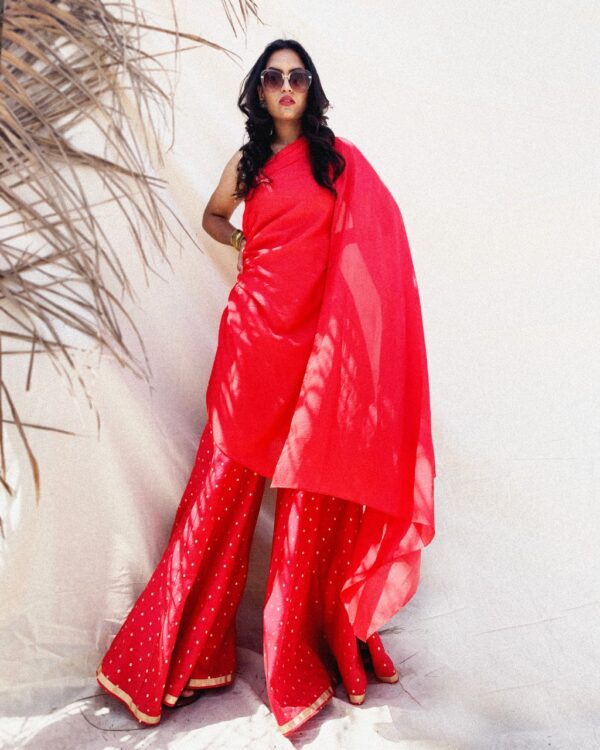 Fiery red asymmetrical kurti in art silk and sharara pants in cotton brocade with polka dots.